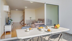 A modern dining area with a table set for breakfast, a sofa, and a staircase leading to another room. - Casa Morena by Atlantic Holiday (Santa Cruz)