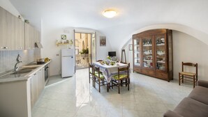 Uma cozinha ampla com área de refeições, um armário embutido e uma televisão.