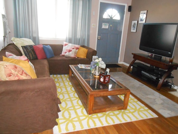 A living room with a sofa, coffee table, and television.