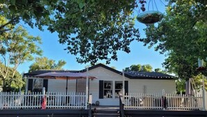 A single-story house with a front porch, a white picket fence, and a hanging planter. - DE-stress in this quiet, serene cottage. Mountains, Horses, Verde River, Peace. (Payson)
