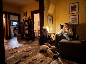 Una sala de estar acogedora con chimenea, una estantería y un comedor con mesa y sillas.