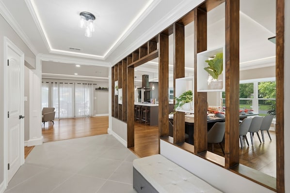 A spacious kitchen with modern appliances, a dining area with chairs, and a view of the outdoors.