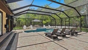 A covered outdoor area with a pool, lounge chairs, and a gazebo. - Lancaster Perfect Vacation HOME - Pool Heating Avail (Clearwater)