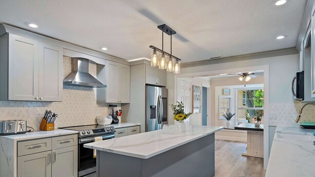 A modern kitchen with a central island, built-in appliances, and a large window. - Lancaster Perfect Vacation HOME - Pool Heating Avail (Clearwater)