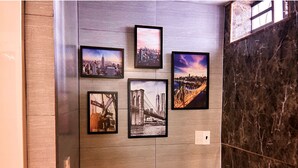 Un mur orné de photographies encadrées représentant des paysages urbains et un pont.