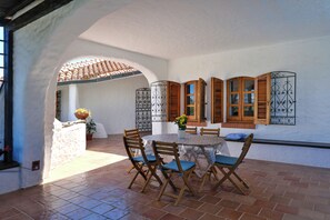 A patio with a round table, chairs, and a potted plant. - Nel blu dipinto di blu⭐⭐⭐⭐⭐ (Sant'Antioco (Maladroxia))