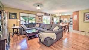 A spacious living room with a sectional sofa, a coffee table, and a dining area with a table and chairs. - Hugo Home, Direct Lake Access & Private Dock! (Hugo)