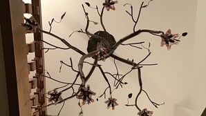 Un escalier doté d’un plafond au design original, orné de motifs de branches et de fleurs.
