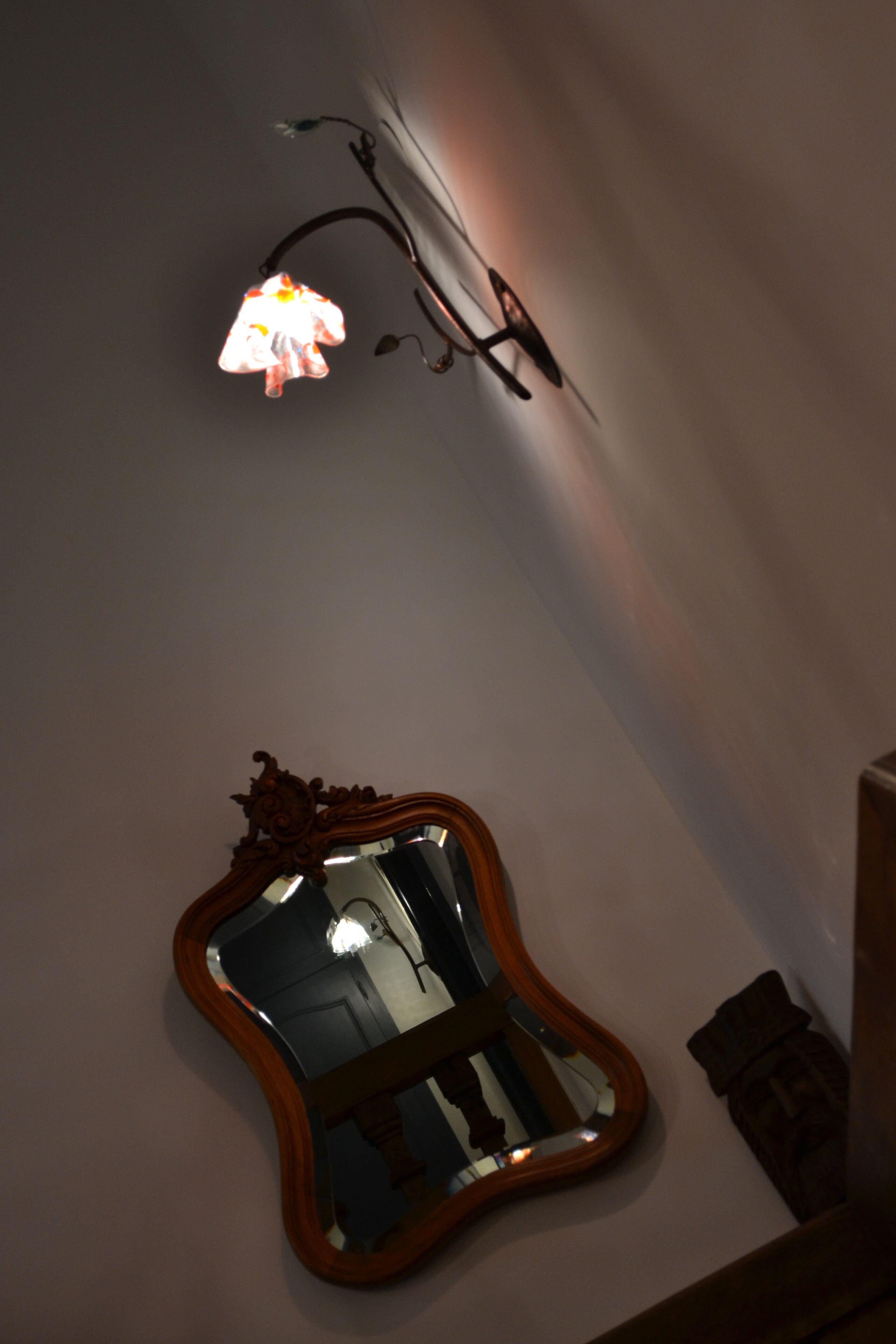 A mirror with an ornate wooden frame on a wall.