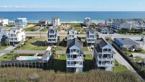 Zona residencial costera con propiedades frente a la playa, incluyendo casas con balcones y piscina.
