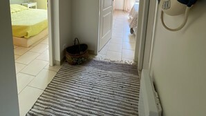 Ein Flur, der in ein Schlafzimmer mit einem Bett, einem Korb und einem Rettungsring an der Wand führt.