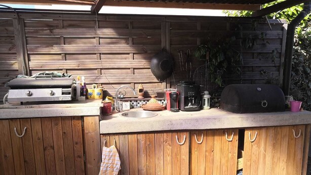 An outdoor kitchen with a grill, coffee maker, and various cooking utensils. - Maison Chaleureuse Dans le Sud (Cournonsec)