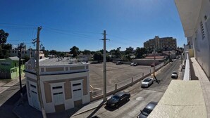 A street view with buildings, cars, and a clear sky. - Apartment Double Bed- Sleeps 2 - Free WIFI (Ponce)