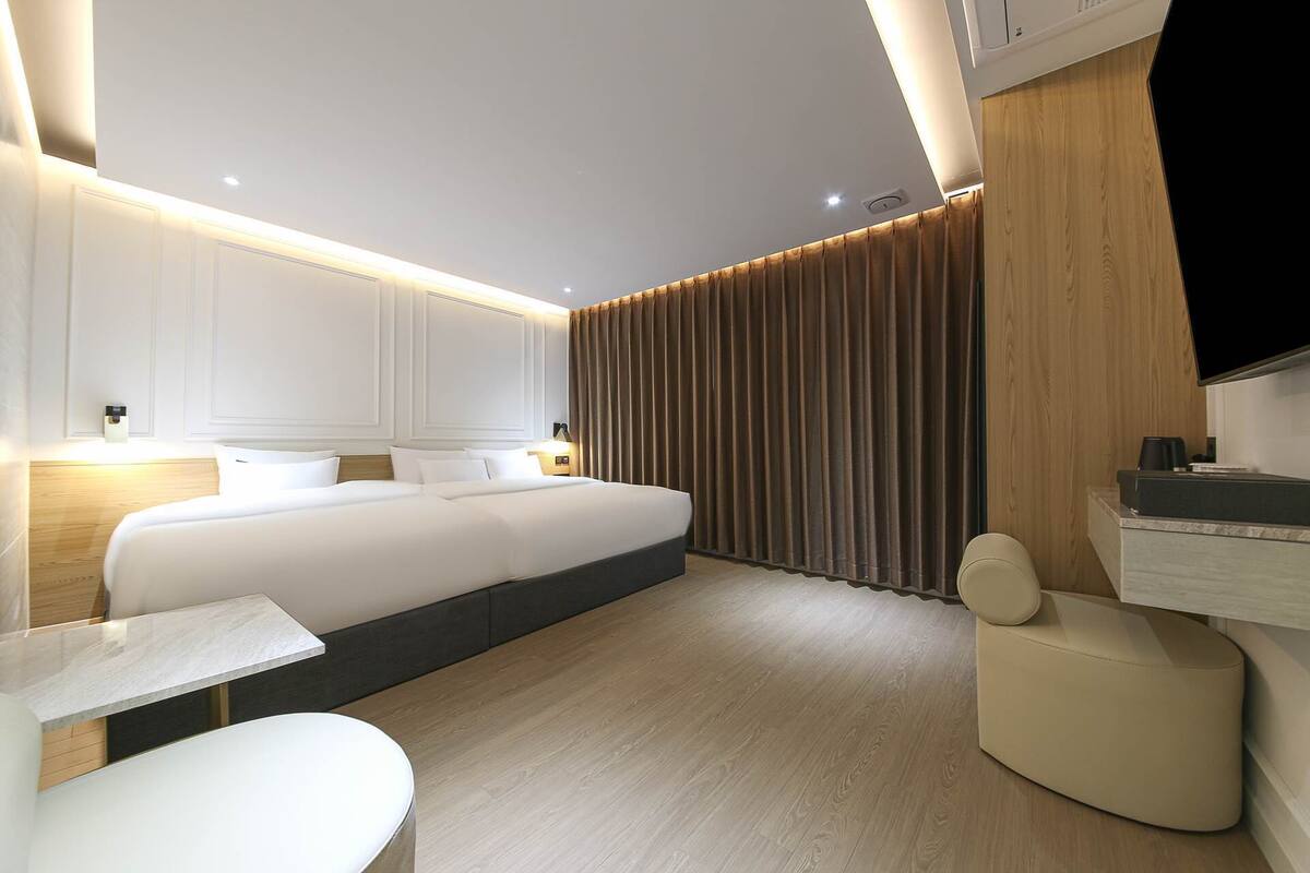 Ein modernes Hotelzimmer mit einem großen Bett, einem Schreibtisch und einer Sitzecke.