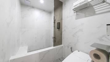 A modern bathroom with a shower, toilet, and a towel rack.
