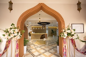 A reception area with a brick archway, a reception desk, and a patterned floor.