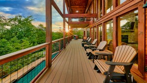 Eine Holzterrasse mit Sitzgelegenheiten und Blick auf den umliegenden Wald.