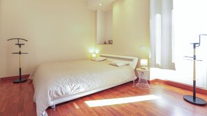 Une chambre à coucher avec un lit, des tables de chevet, une lampe et une fenêtre.