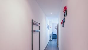 Un couloir avec un banc, un porte-manteau et des éléments décoratifs sur les murs.