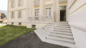 Un immeuble à plusieurs étages, avec un escalier menant à l’entrée.