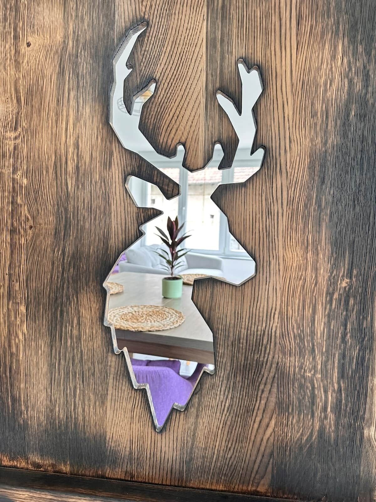 A wooden wall with a deer head cutout.