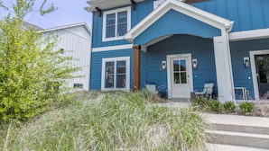 A two-story house with a blue exterior, white trim, and a front door with a number '504' sign.