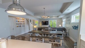 A spacious kitchen with a central island, wooden flooring, and a chandelier.
