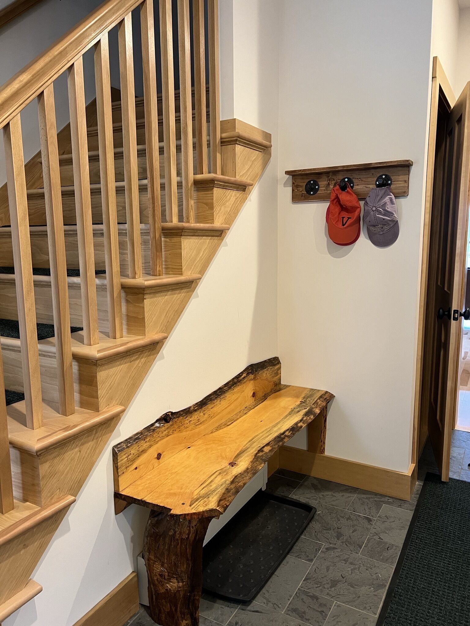 Eine Holztreppe mit einer Bank am Fuß.