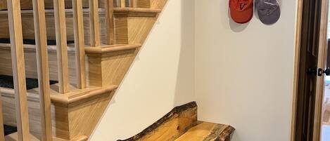 Eine Holztreppe mit einer Bank am Fuß.