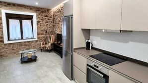 A modern kitchen with a built-in oven, a stainless steel refrigerator, and a black induction cooktop. - Tourist House in the center of Vilafamés (Vilafamés)