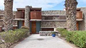 Un bâtiment aux murs en pierre, doté de balcons en bois et bordé d’un chemin pavé.