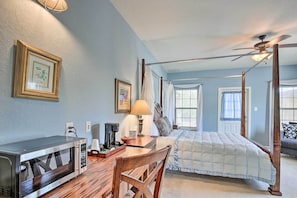 Classic hotel room with a four-poster bed, desk, and window view.