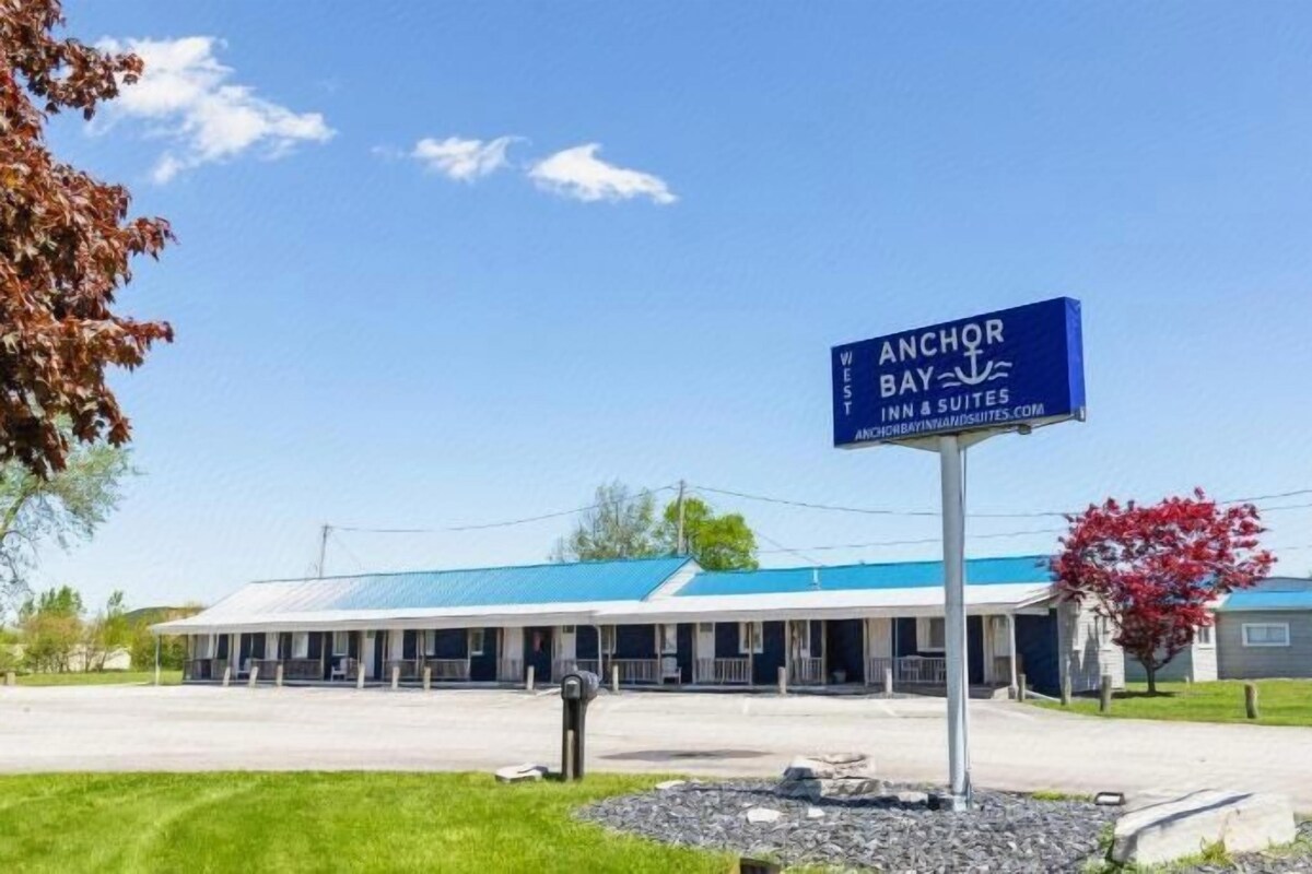 Un hôtel avec un toit bleu, une enseigne et un parking.