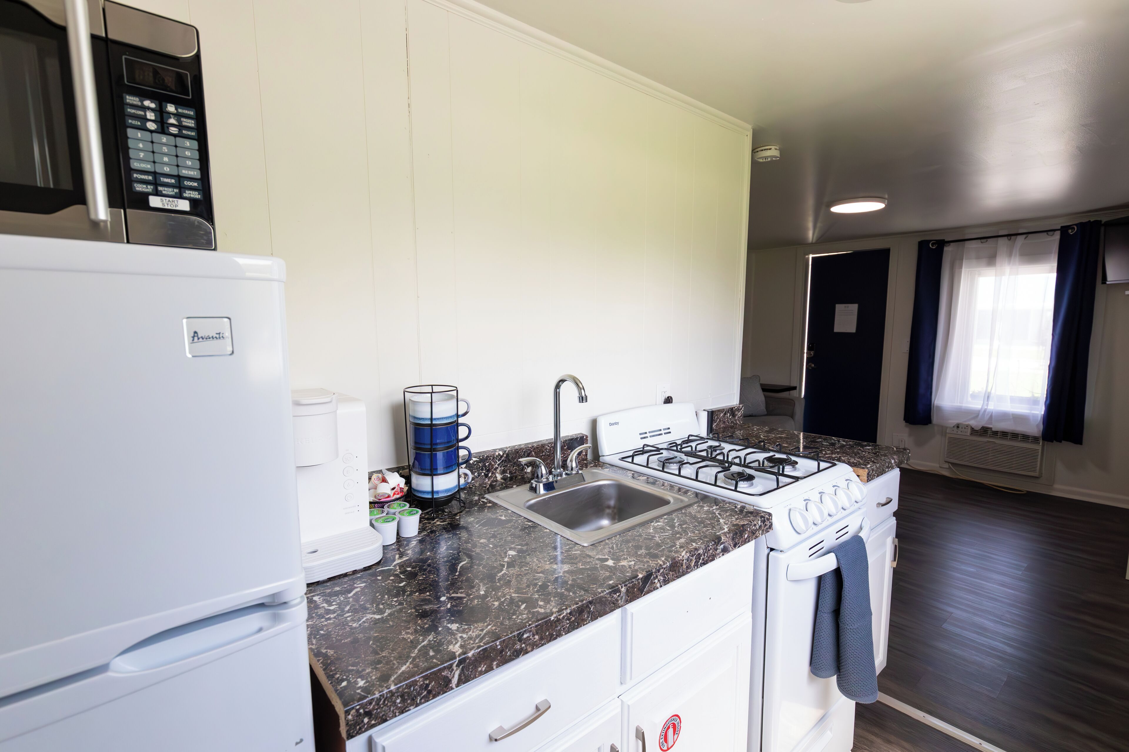 Une cuisine moderne équipée d’un four à micro-ondes, d’une cuisinière et d’un évier intégrés.