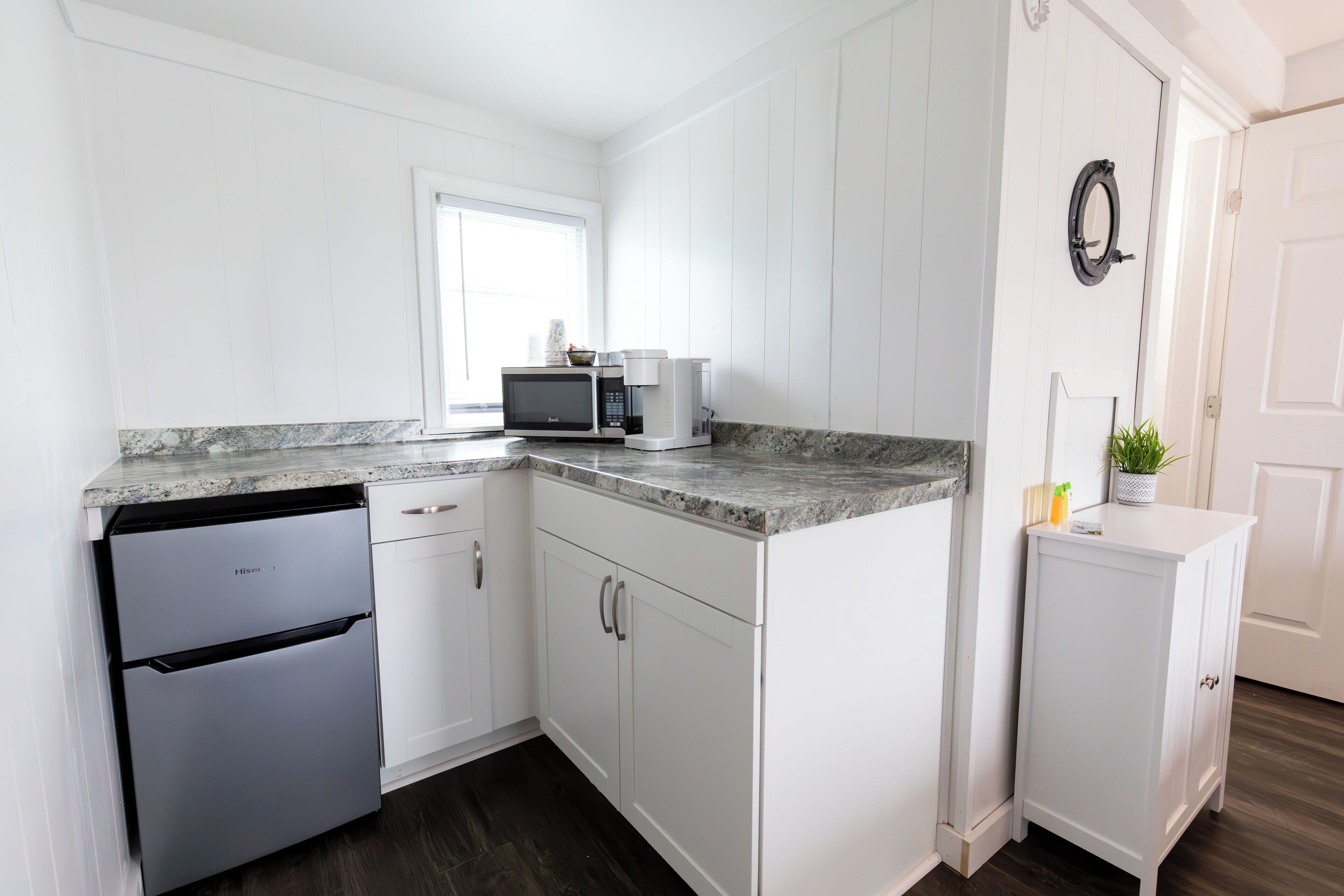 A kitchen with white cabinetry, a built-in microwave, and a dishwasher.