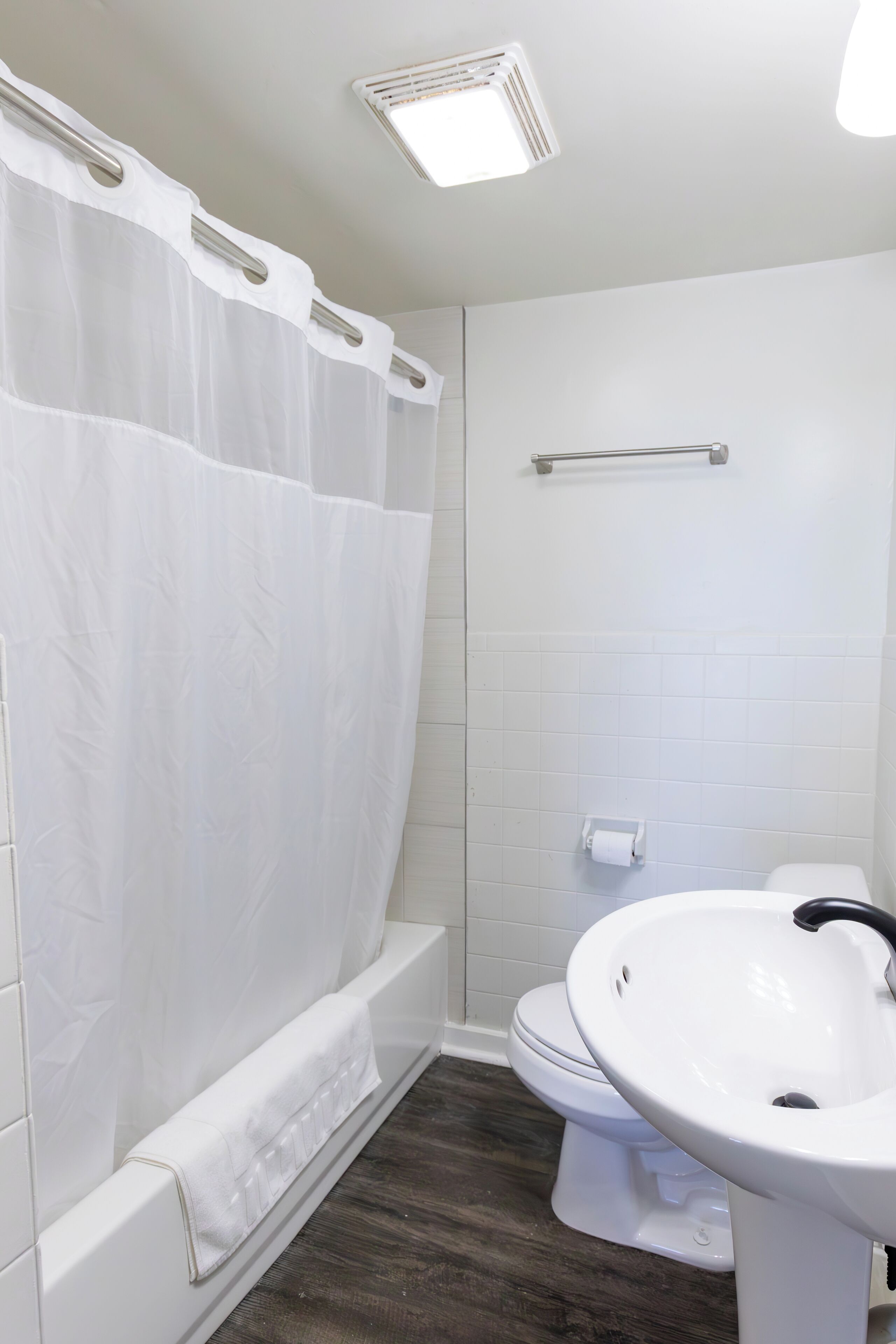 A bathroom with a white bathtub, a toilet, and a sink.