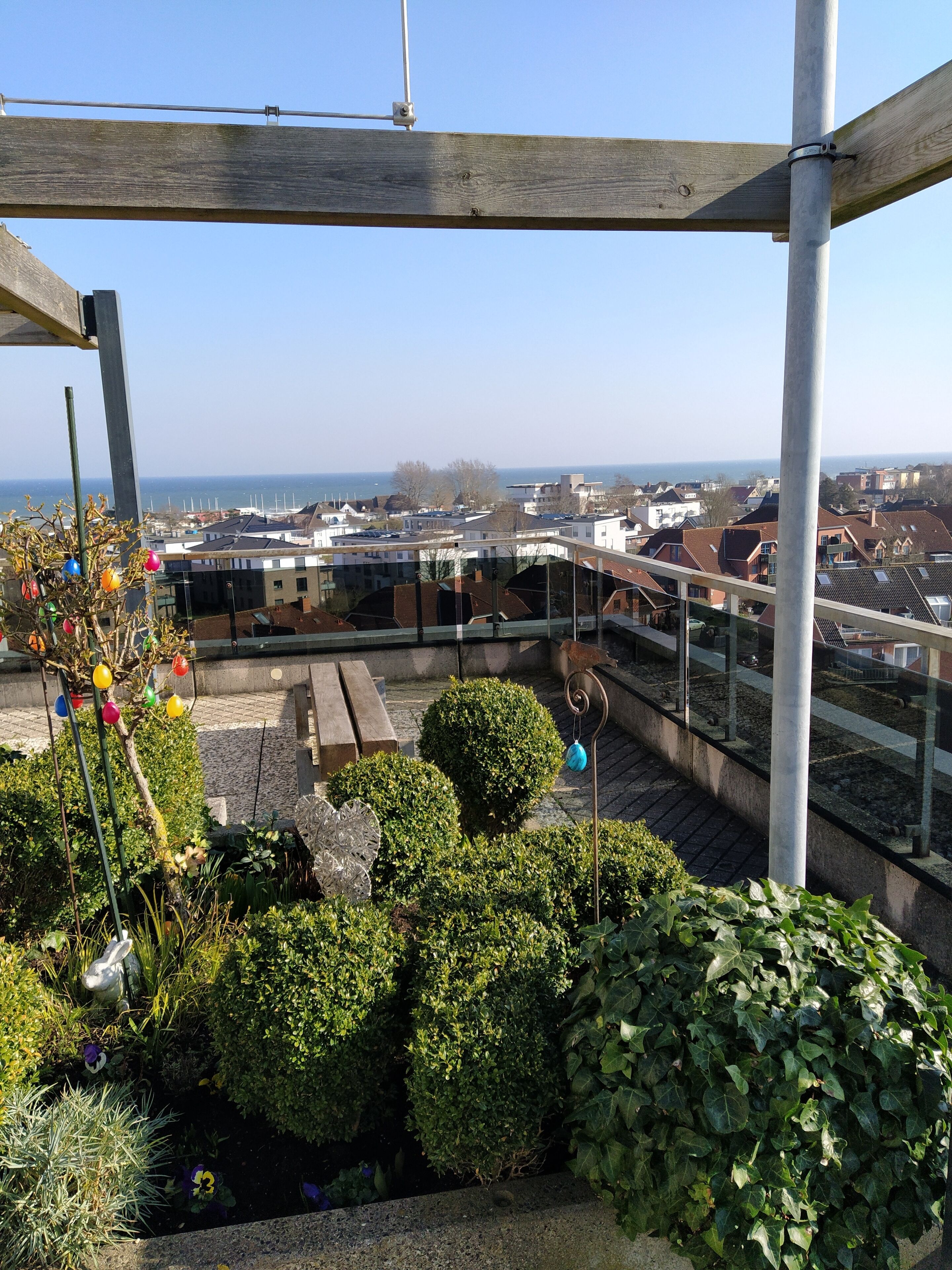 A rooftop garden with a view of the city and the sea.