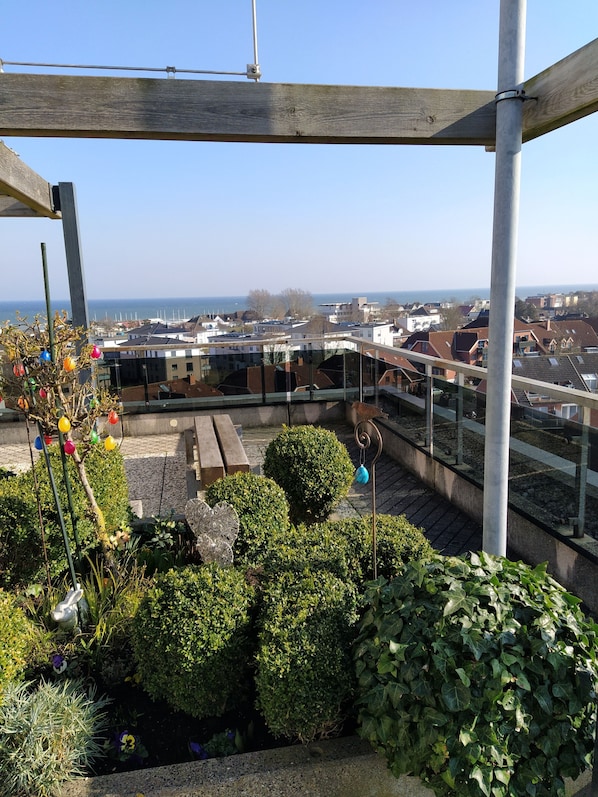 Un jardín en la azotea con vistas a la ciudad y al mar.