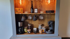 A kitchen with wooden cabinets, a coffee machine, and various kitchenware. - Near Châteaux & zoo de beauval: Gîte de sologne (Pruniers-en-Sologne)