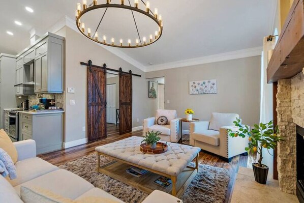 Una sala de estar moderna con chimenea, comedor y cocina.