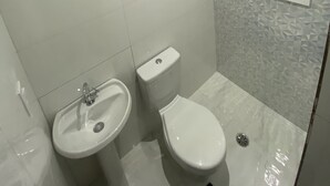 Un baño con inodoro, lavamanos y ducha.