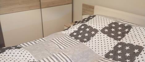Una cama con colcha acolchada que presenta diseños geométricos.