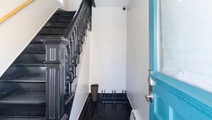 Una escalera con barandillas negras y una puerta azul.