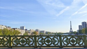 A cityscape with modern buildings, a prominent tower, and a river. - Paris - Porte D'auteuil : Grand Studio Avec Balcon (Paris)