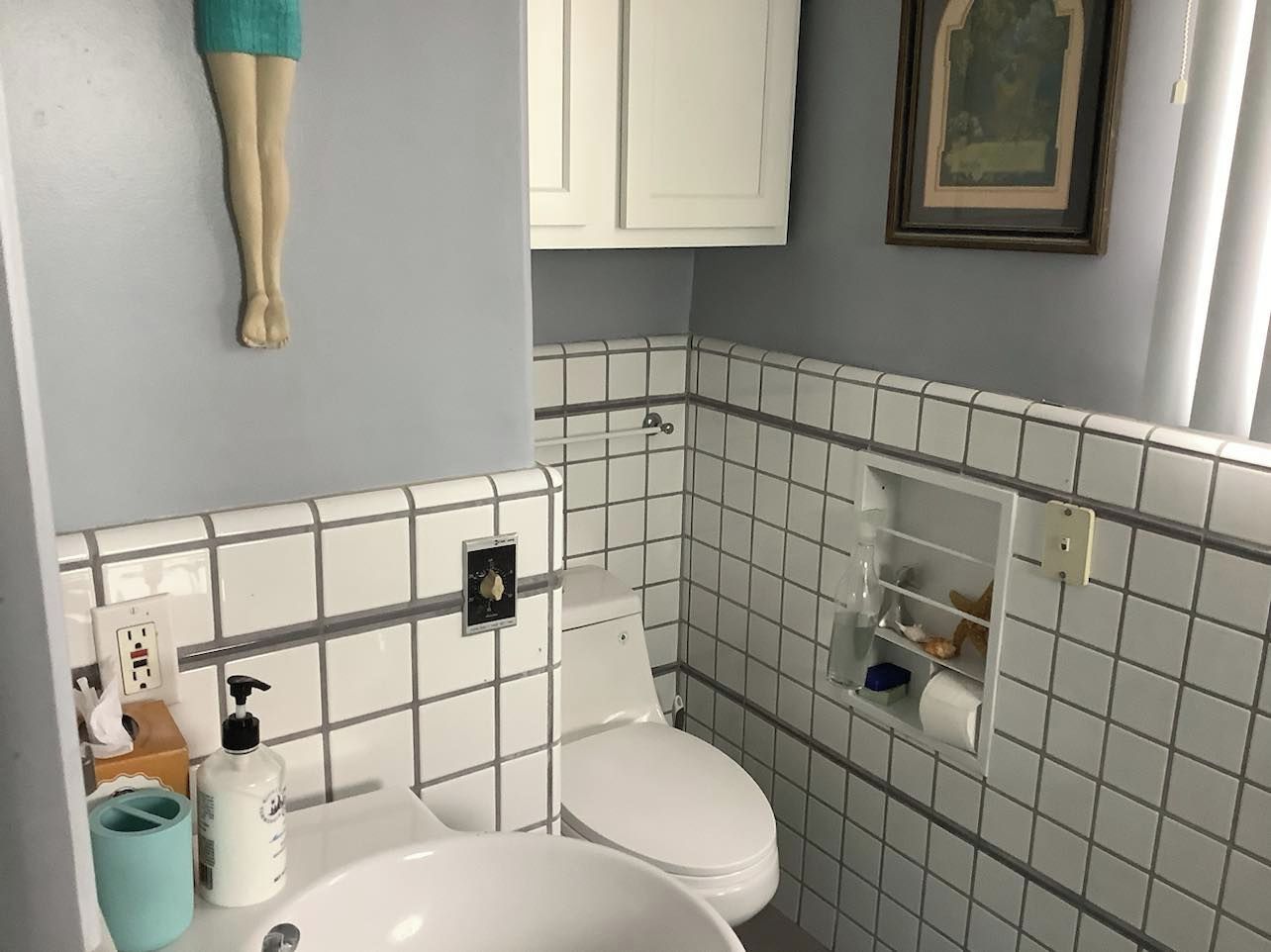 A bathroom with a toilet, sink, and a towel rack.