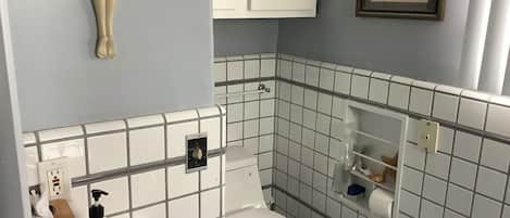 A bathroom with a toilet, sink, and a towel rack.