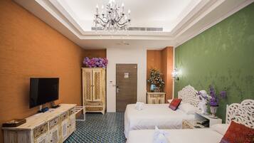 A hotel room with two beds, a television, a cabinet with decorative items, and a patterned floor.