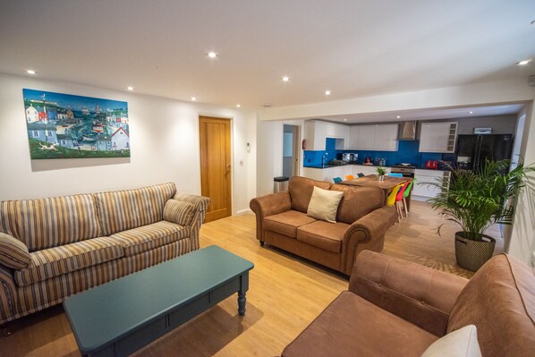 Ein modernes Wohnzimmer mit gestreiften Sofas, einem Couchtisch und einem großen Gemälde einer Küstenstadt.