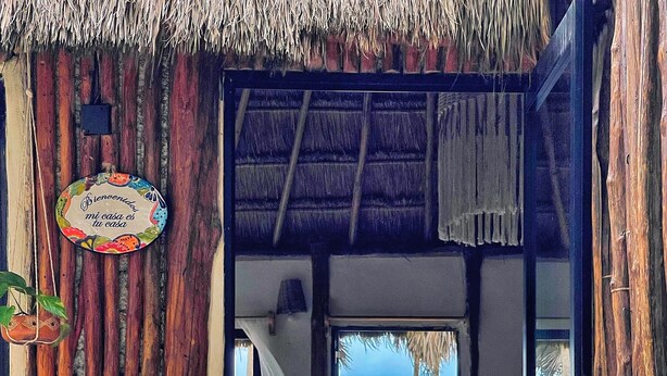 A wooden structure with a thatched roof, a welcome sign, and a view of the ocean. - Beautiful cottage in front of the sea. Tulum. (Tulum)