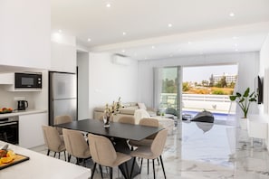 Une cuisine moderne avec un coin repas, un canapé et une vue sur une piscine.